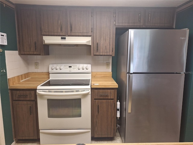 4420 Sawgrass Blvd, New Port Richey, FL 34653 - kitchen with freestanding refrigerator, white range with electric stovetop, under cabinet range hood, and decorative backsplash