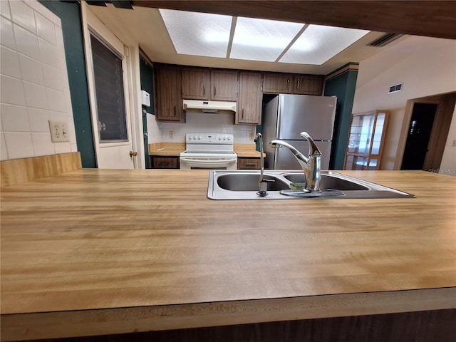 4420 Sawgrass Blvd, New Port Richey, FL 34653 - kitchen with white electric stove, freestanding refrigerator, under cabinet range hood, butcher block counters, and backsplash