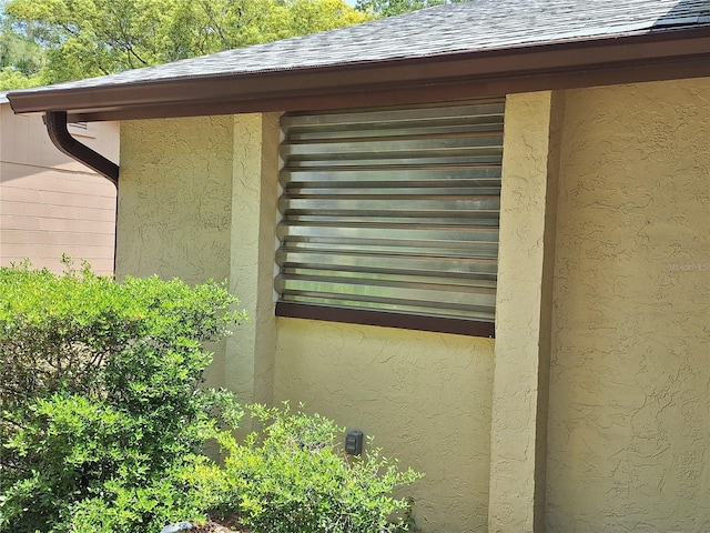 4420 Sawgrass Blvd, New Port Richey, FL 34653 - exterior view of a downspout, stucco siding, a shingled roof, and gutters