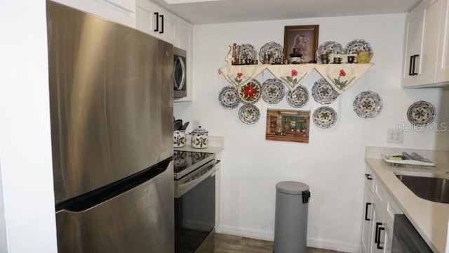 5434 Chad Pl Unit 14, New Port Richey, FL 34652 - kitchen with appliances with stainless steel finishes, light countertops, white cabinets, and wood finished floors