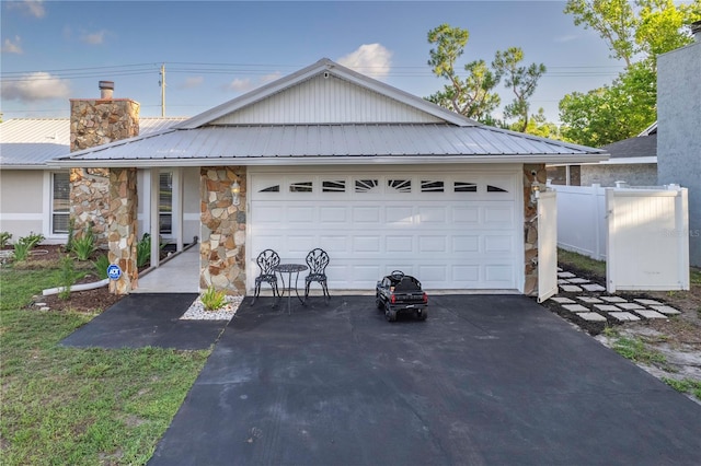 5520 Fulmar Dr, Tampa, FL 33625 - ranch-style home with stone siding, a chimney, asphalt driveway, a metal roof, and an attached garage
