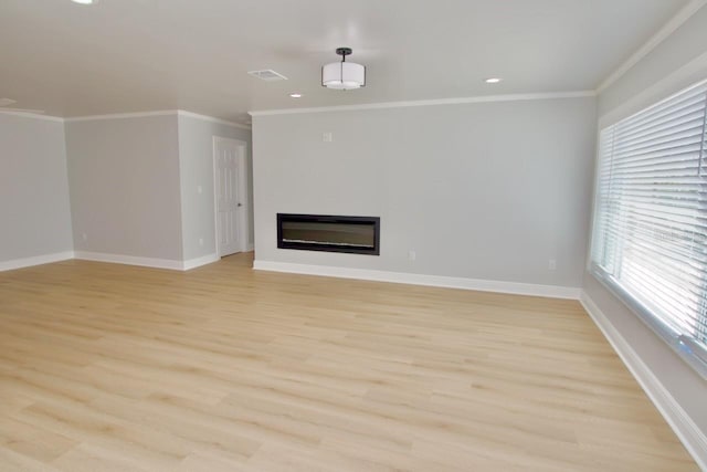 5339 Bowline Bnd, New Port Richey, FL 34652 - unfurnished living room featuring light wood-style flooring, a glass covered fireplace, recessed lighting, and ornamental molding