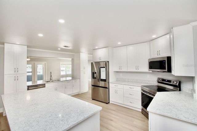 5339 Bowline Bnd, New Port Richey, FL 34652 - kitchen featuring stainless steel appliances, light wood-style floors, light stone countertops, and recessed lighting