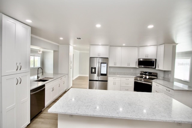 5339 Bowline Bnd, New Port Richey, FL 34652 - kitchen with stainless steel appliances, white cabinetry, light wood finished floors, recessed lighting, and light stone countertops