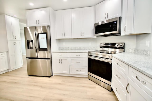 5339 Bowline Bnd, New Port Richey, FL 34652 - kitchen with stainless steel appliances, white cabinetry, light wood finished floors, recessed lighting, and light stone countertops