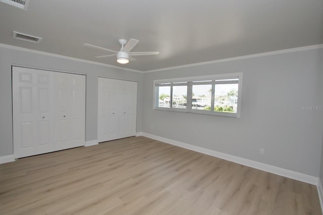 5339 Bowline Bnd, New Port Richey, FL 34652 - unfurnished bedroom featuring multiple closets, light wood finished floors, crown molding, and a ceiling fan