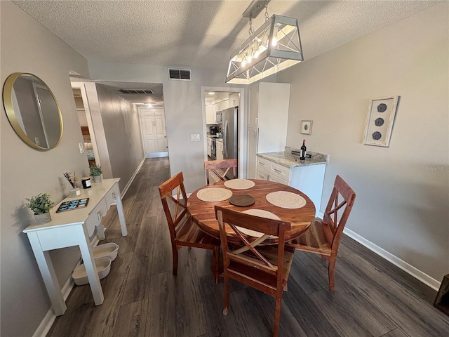 5555 Gulf Blvd Unit 315, St Pete Beach, FL 33706 - dining area with a textured ceiling and dark wood finished floors