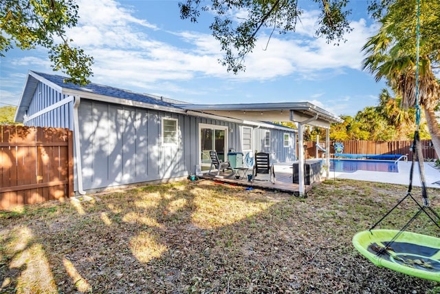 15950 Adobe Dr, Hudson, FL 34667 - rear view of property featuring board and batten siding, a fenced backyard, and a deck