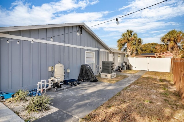 15950 Adobe Dr, Hudson, FL 34667 - view of property exterior with board and batten siding, a gate, and a patio area