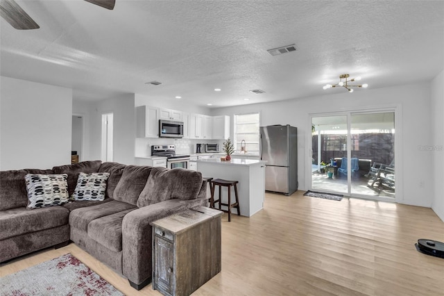 15950 Adobe Dr, Hudson, FL 34667 - living room featuring light wood finished floors, a textured ceiling, ceiling fan, and recessed lighting