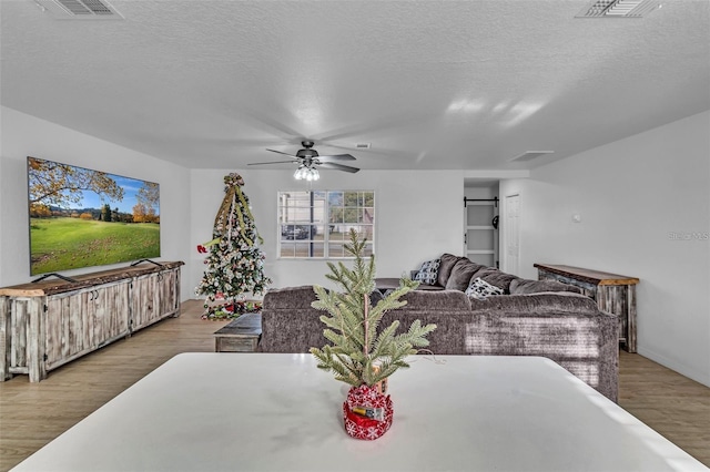 15950 Adobe Dr, Hudson, FL 34667 - dining room featuring a ceiling fan, a textured ceiling, and wood finished floors