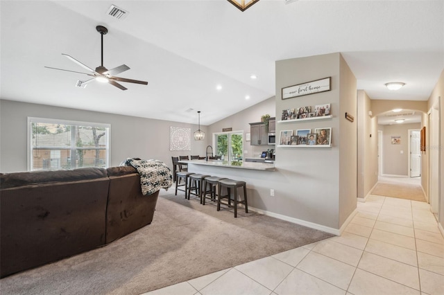 11034 Flock Ave, Weeki Wachee, FL 34613 - living room with light carpet, arched walkways, light tile patterned flooring, lofted ceiling, and ceiling fan
