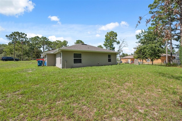 11034 Flock Ave, Weeki Wachee, FL 34613 - rear view of house with stucco siding and a lawn