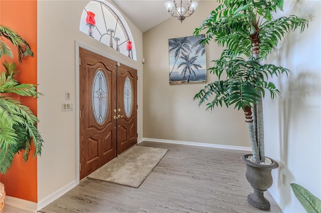 entrance foyer featuring a chandelier, wood finished floors, and high vaulted ceiling