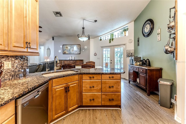 kitchen with dishwasher, a peninsula, french doors, dark stone countertops, and light wood-style floors