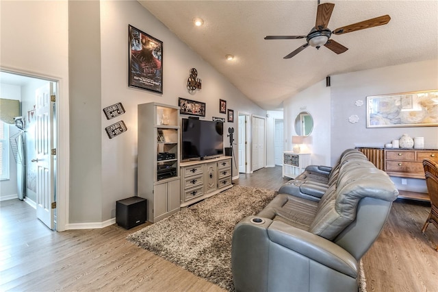 living area with a ceiling fan, light wood-style floors, and lofted ceiling