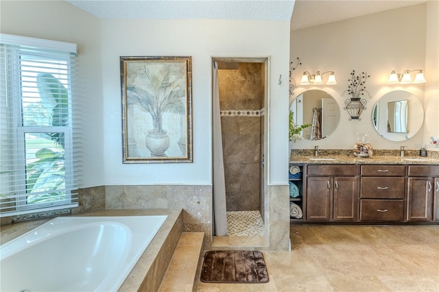 bathroom with a bath, double vanity, tiled shower, and tile patterned floors