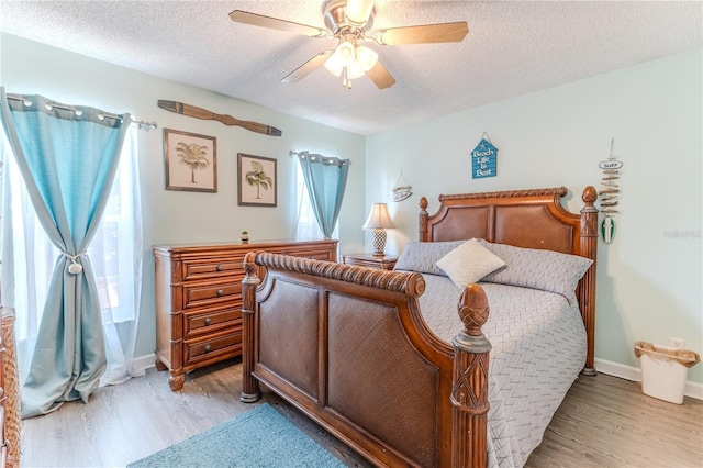 bedroom with light wood-style floors, a textured ceiling, and ceiling fan