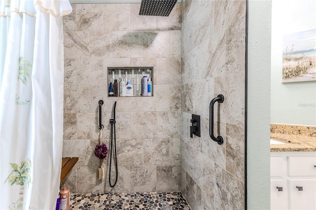 bathroom featuring tiled shower and vanity