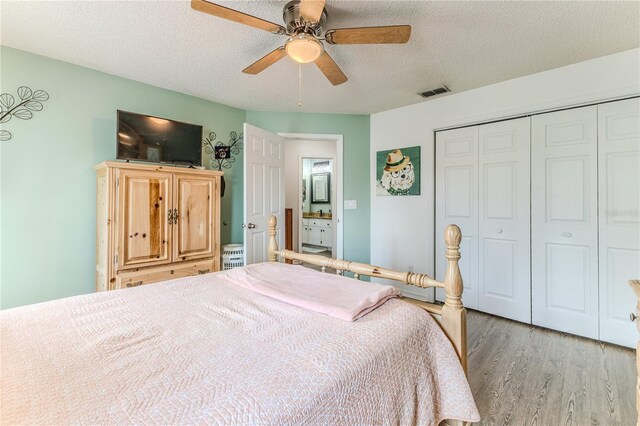 bedroom with wood finished floors, a closet, a textured ceiling, and a ceiling fan