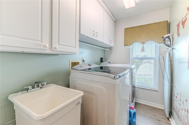 laundry room featuring cabinet space, washer and dryer, and light wood finished floors