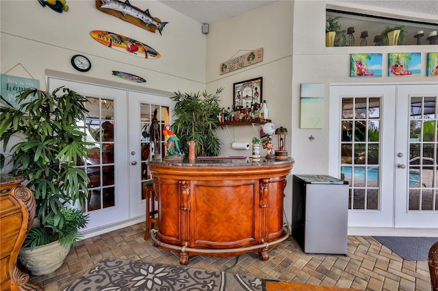 indoor bar featuring french doors and brick patterned floors