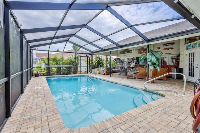 swimming pool featuring french doors, a patio, and a lanai