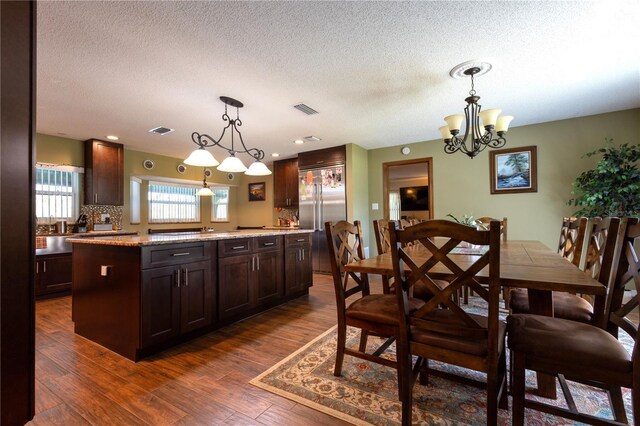 7550 Jomel Dr, Weeki Wachee, FL 34607 - dining space with a chandelier, dark wood-style floors, and a textured ceiling