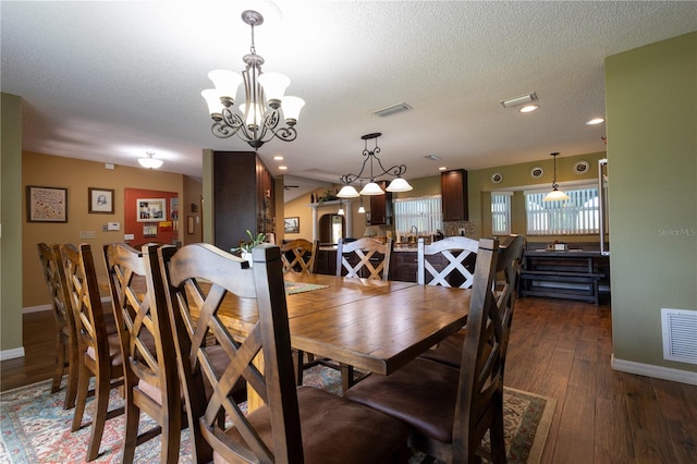 7550 Jomel Dr, Weeki Wachee, FL 34607 - dining room featuring a chandelier, dark wood finished floors, and a textured ceiling