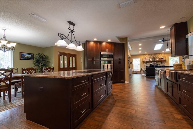 7550 Jomel Dr, Weeki Wachee, FL 34607 - kitchen with ceiling fan, a textured ceiling, dark wood-style flooring, a chandelier, and stainless steel appliances