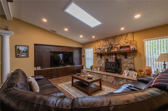 7550 Jomel Dr, Weeki Wachee, FL 34607 - living area with light wood-style floors, a wood stove, vaulted ceiling, recessed lighting, and a textured ceiling