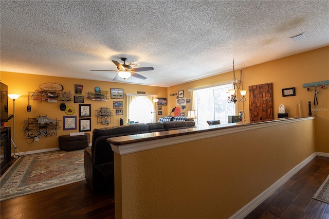 7550 Jomel Dr, Weeki Wachee, FL 34607 - living area featuring dark wood-type flooring, a textured ceiling, ceiling fan, and a chandelier