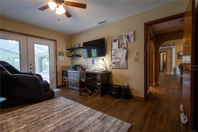 7550 Jomel Dr, Weeki Wachee, FL 34607 - home office featuring a ceiling fan, dark wood-type flooring, french doors, arched walkways, and a textured ceiling