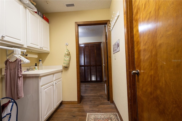 7550 Jomel Dr, Weeki Wachee, FL 34607 - laundry room featuring dark wood-style flooring and a textured ceiling