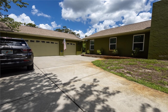 7550 Jomel Dr, Weeki Wachee, FL 34607 - view of front of home with driveway, stucco siding, and a garage
