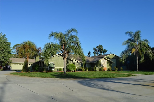 7550 Jomel Dr, Weeki Wachee, FL 34607 - ranch-style house featuring concrete driveway, a front yard, stucco siding, and a garage