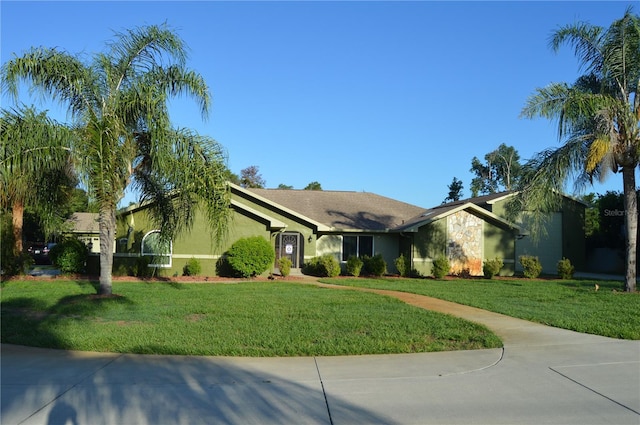 7550 Jomel Dr, Weeki Wachee, FL 34607 - view of front of home with stucco siding, a front lawn, and a garage