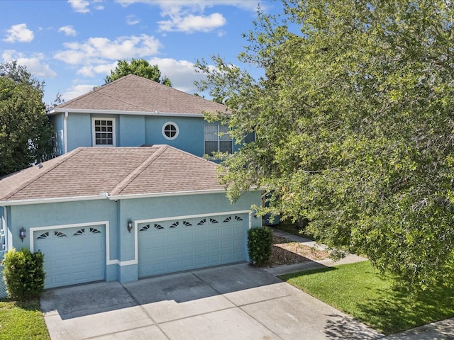4481 Birchfield Loop, Spring Hill, FL 34609 - view of front facade with stucco siding, an attached garage, driveway, and roof with shingles