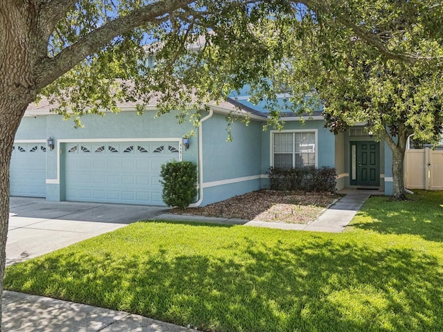 4481 Birchfield Loop, Spring Hill, FL 34609 - view of front of home with stucco siding, a garage, a front lawn, and driveway