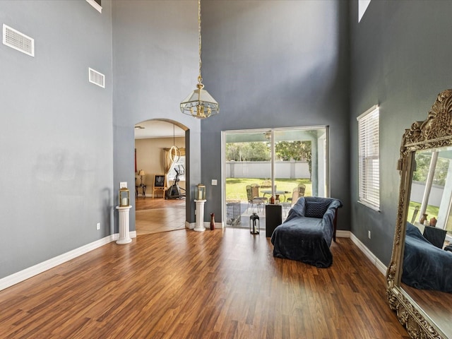 4481 Birchfield Loop, Spring Hill, FL 34609 - sitting room featuring a high ceiling, arched walkways, wood finished floors, and healthy amount of natural light