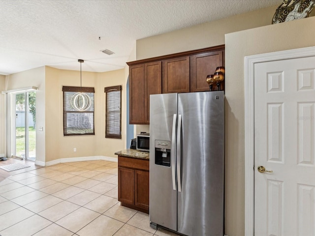 4481 Birchfield Loop, Spring Hill, FL 34609 - kitchen featuring appliances with stainless steel finishes, light tile patterned flooring, a textured ceiling, stone counters, and pendant lighting