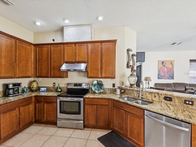 4481 Birchfield Loop, Spring Hill, FL 34609 - kitchen with stainless steel appliances, extractor fan, light stone counters, light tile patterned flooring, and a textured ceiling