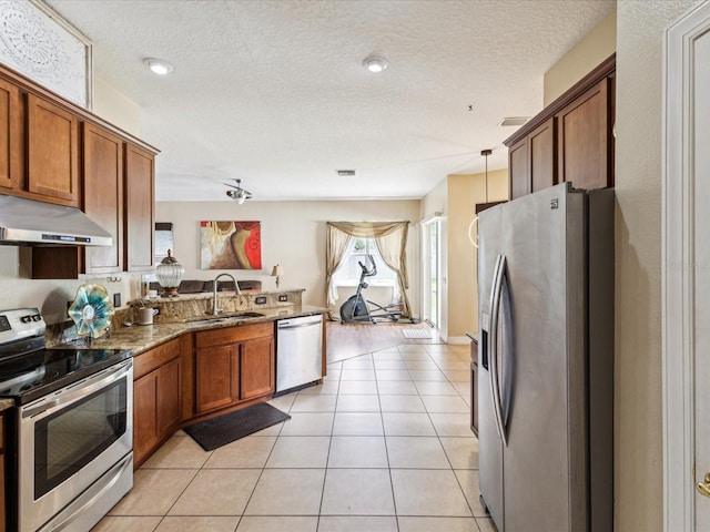 4481 Birchfield Loop, Spring Hill, FL 34609 - kitchen featuring stainless steel appliances, under cabinet range hood, a peninsula, brown cabinets, and stone counters
