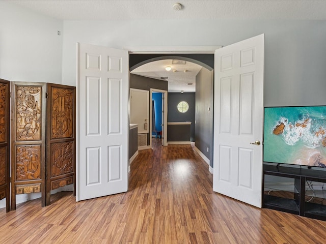 4481 Birchfield Loop, Spring Hill, FL 34609 - hallway featuring arched walkways and wood finished floors