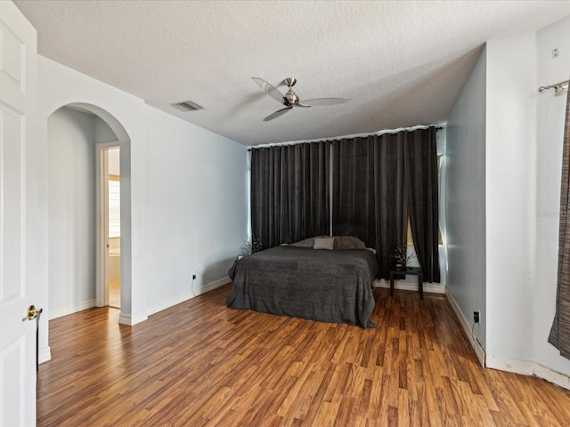 4481 Birchfield Loop, Spring Hill, FL 34609 - bedroom with wood finished floors, arched walkways, a textured ceiling, and ceiling fan