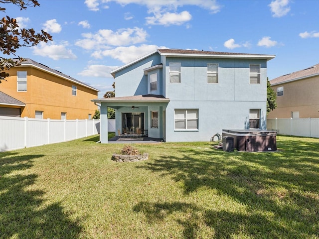 4481 Birchfield Loop, Spring Hill, FL 34609 - back of property featuring a hot tub, ceiling fan, a fenced backyard, a patio, and stucco siding