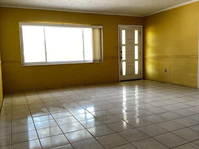 723 W Bayshore Dr, Tarpon Springs, FL 34689 - spare room with light tile patterned floors, a textured ceiling, and ornamental molding