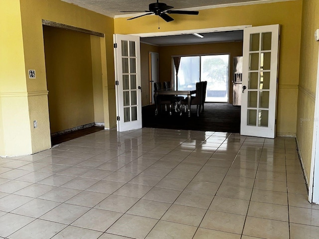 723 W Bayshore Dr, Tarpon Springs, FL 34689 - spare room featuring french doors, light tile patterned floors, a ceiling fan, and ornamental molding