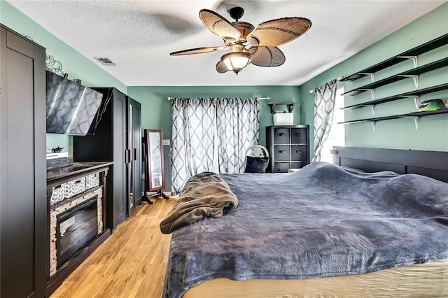 364 Waterfall Dr, Spring Hill, FL 34608 - bedroom with light wood finished floors, ceiling fan, and a textured ceiling
