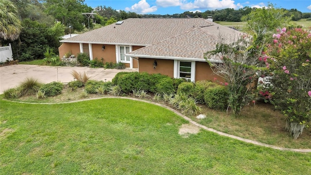 364 Waterfall Dr, Spring Hill, FL 34608 - view of front facade with stucco siding, a front yard, and roof with shingles